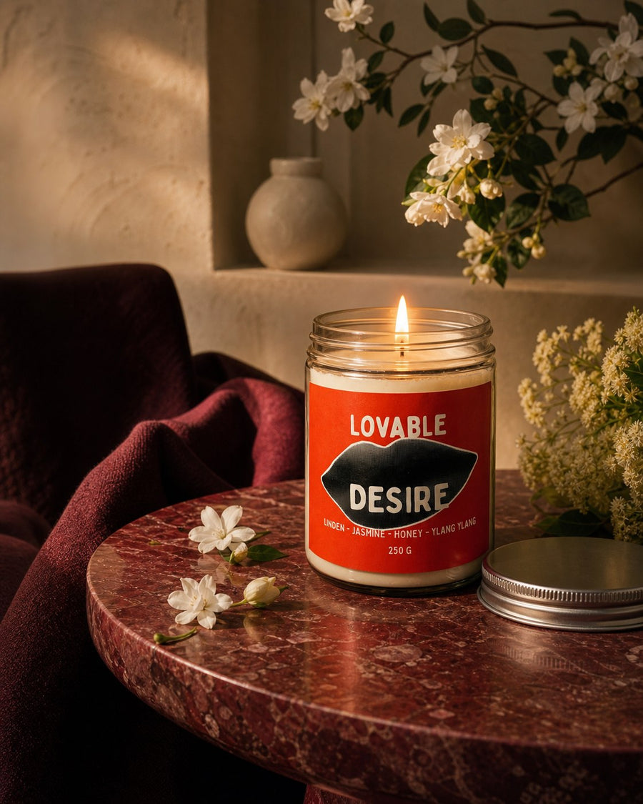 Lumânare DESIRE aprinsă într-un interior elegant, pe o masă din piatră oxblood